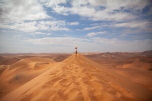 Guest standing on a Namib dune near The Desert Grace