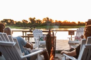 Guests watching the sunset from the river deck at Zambezi Mubala Camp