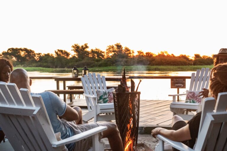Guests watching the sunset from the river deck at Zambezi Mubala Camp