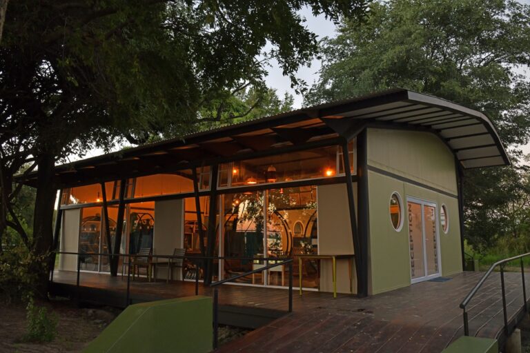 Main lodge building among riverside trees at Zambezi Mubala Lodge