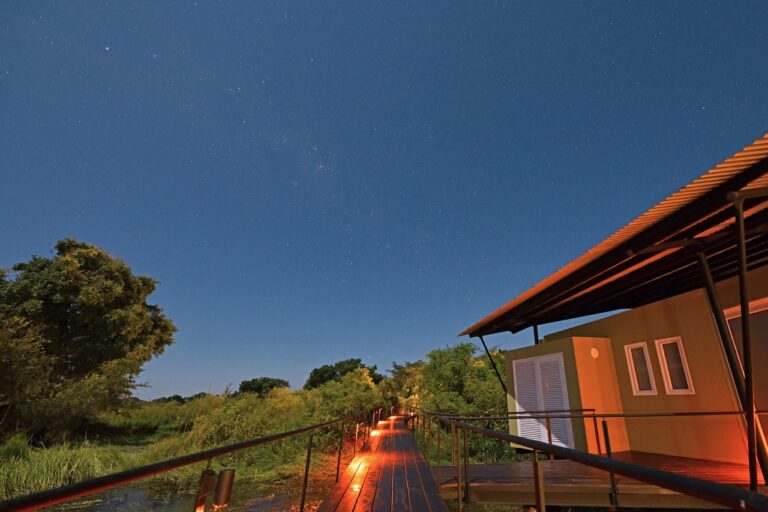 Zambezi River lodge bungalow and illuminated walkway at night