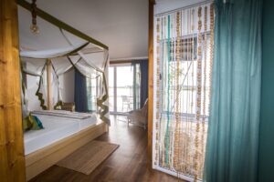 Mosquito-netted bedroom opening onto the river deck