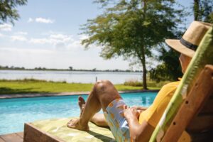Guest relaxing beside the Zambezi Mubala Lodge swimming pool