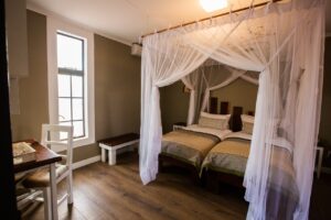Double room with mosquito net at Kalahari Anib Lodge