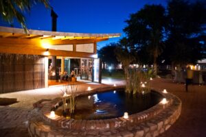 Kalahari Anib Lodge pool and terrace illuminated at dusk