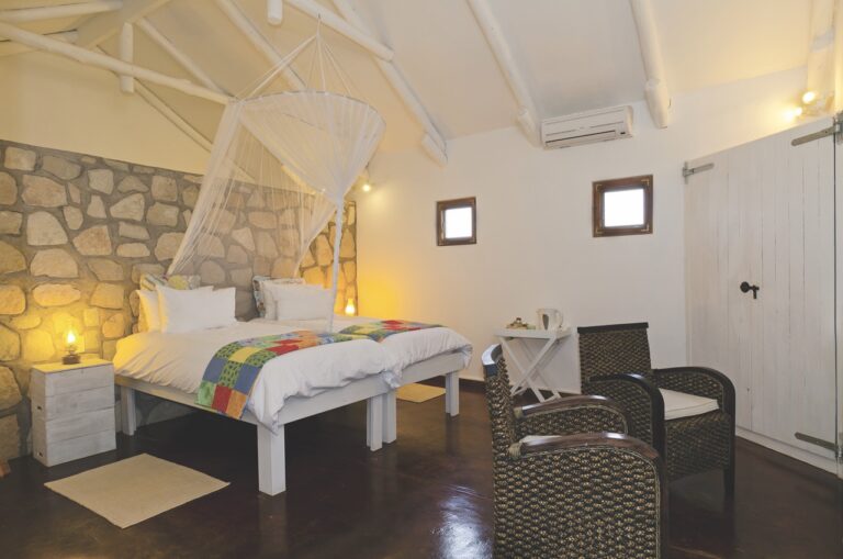Twin bungalow bedroom with mosquito nets at Kalahari Farmhouse