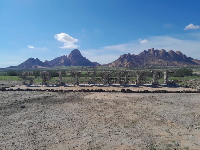 Spitzkoppe entrance sign with the granite mountains beyond