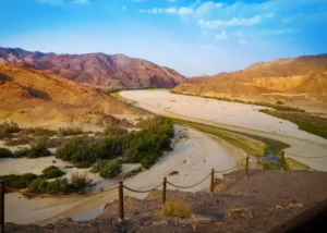 Broad sandy river valley among colourful desert hills on the Skeleton Coast Safari