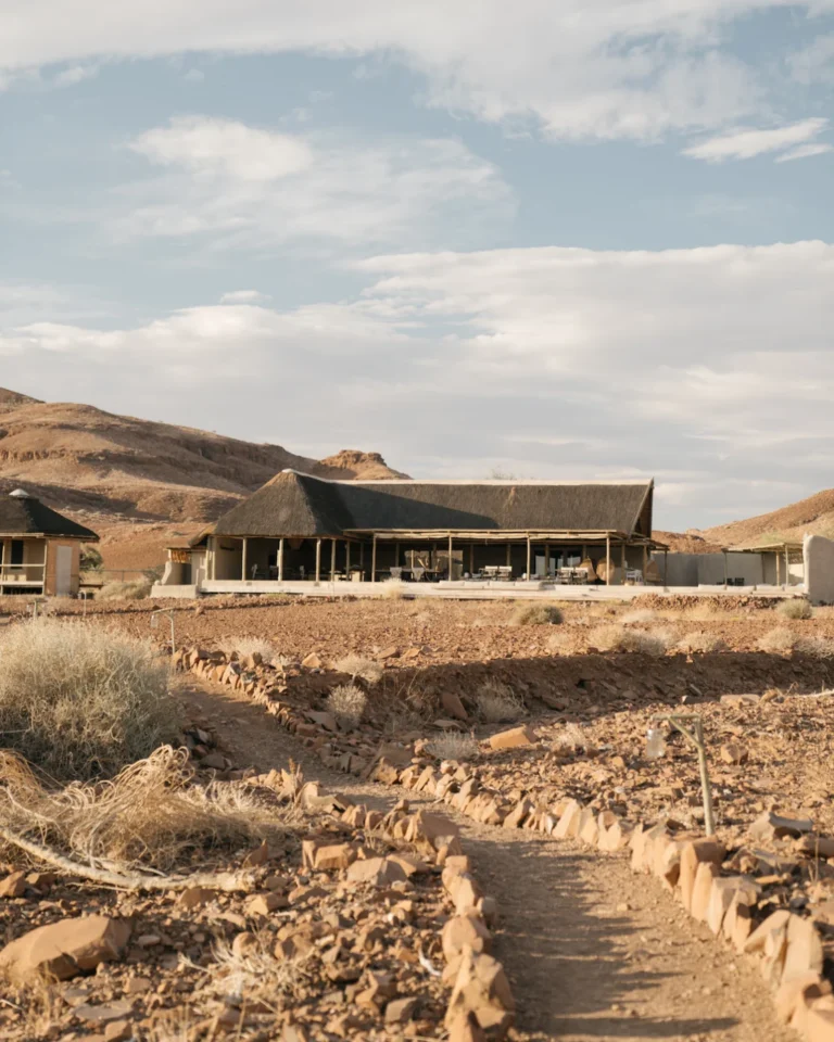 Thatched Damaraland Camp suite in a rocky desert setting
