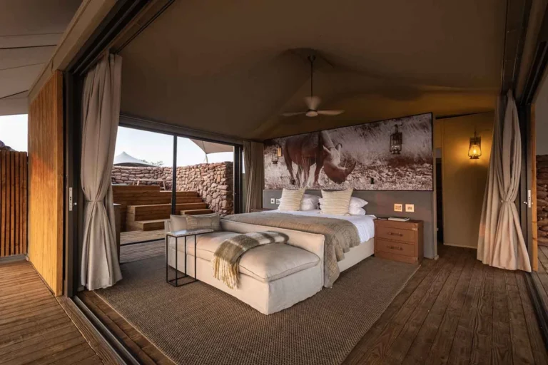 Bed and sitting area inside a Desert Rhino Camp suite