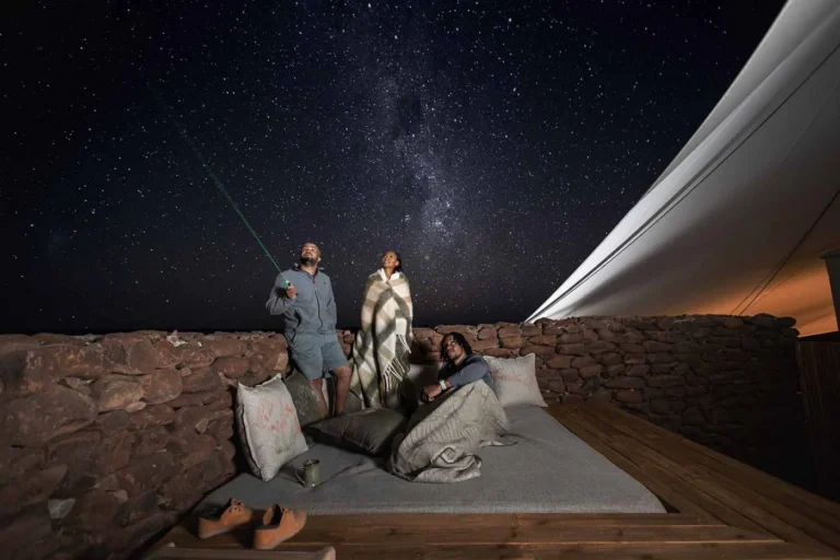 Guests looking at the night sky from a Desert Rhino Camp deck