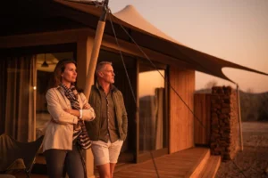 Guests on a Desert Rhino Camp suite deck in evening light