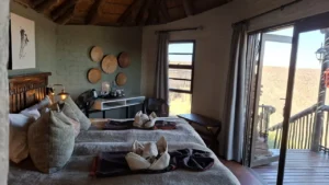 Twin beds and private deck doors at Grootberg Lodge