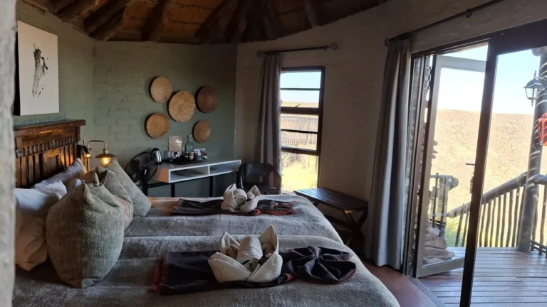 Twin beds and private deck doors at Grootberg Lodge