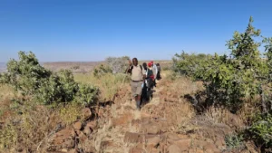 Guests walking through rocky terrain near Grootberg Lodge