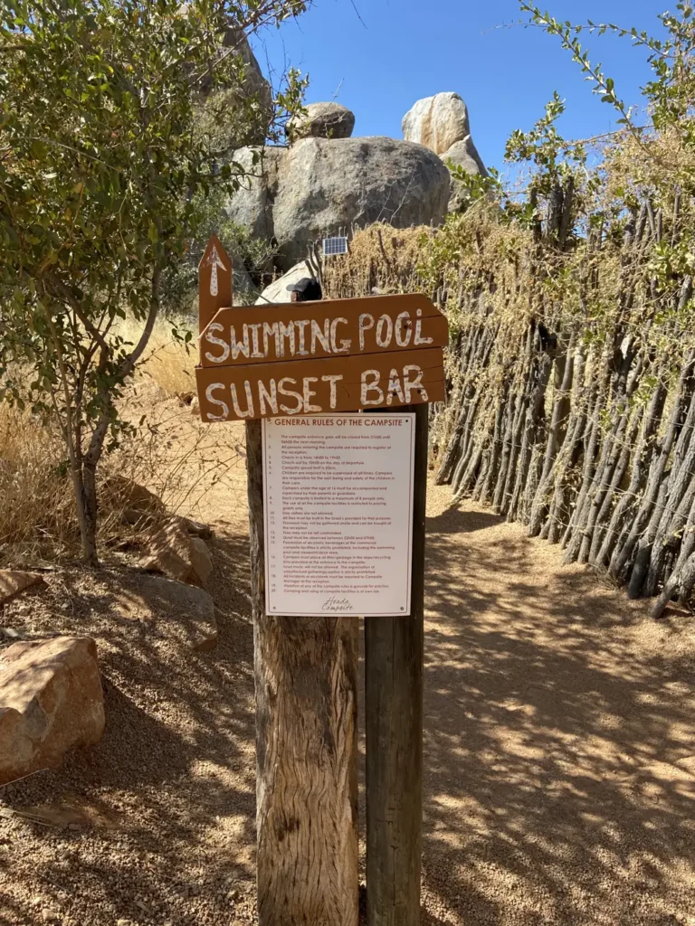 Hoada camp sign beside a wooden fence