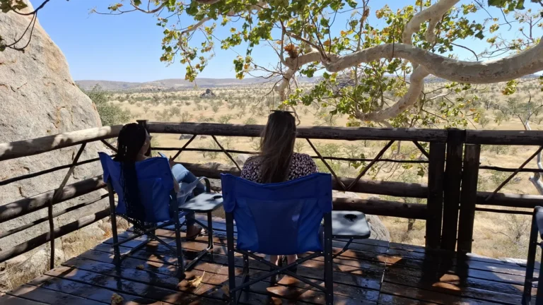 Guests seated on a timber deck among the rocks at Hoada