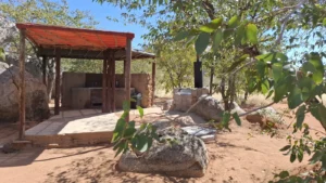 Campsite facilities beneath a red shade canopy at Hoada