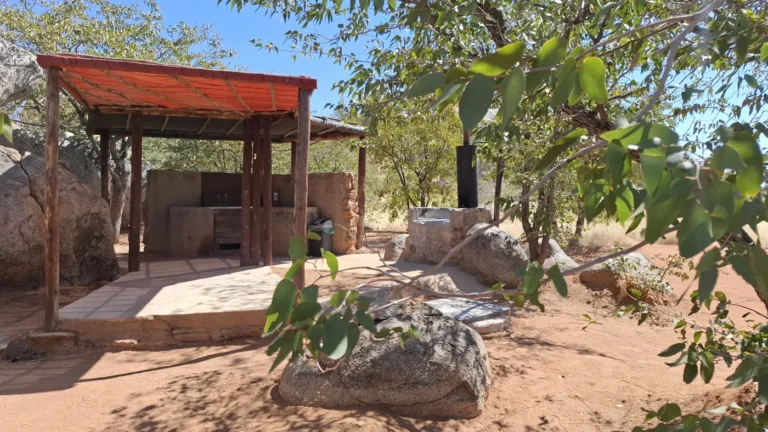 Campsite facilities beneath a red shade canopy at Hoada
