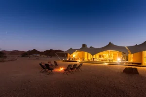 Illuminated Hoanib Skeleton Coast Camp and fire circle at dusk