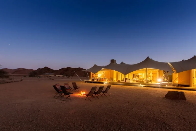 Illuminated Hoanib Skeleton Coast Camp and fire circle at dusk