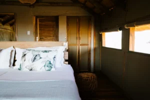 Bed and canvas walls inside a Kulala Desert Lodge guest room
