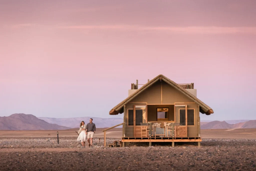 Canvas-and-thatch guest chalet at Kulala Desert Lodge