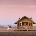 Canvas-and-thatch guest chalet at Kulala Desert Lodge