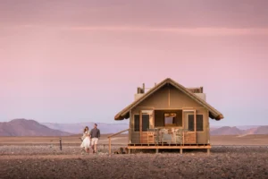 Canvas-and-thatch guest chalet at Kulala Desert Lodge