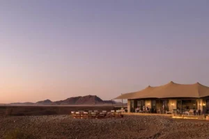 Main buildings of Kulala Desert Lodge at dusk in the Namib Desert