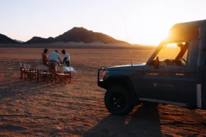 Sunset drinks beside a safari vehicle in the Kulala reserve