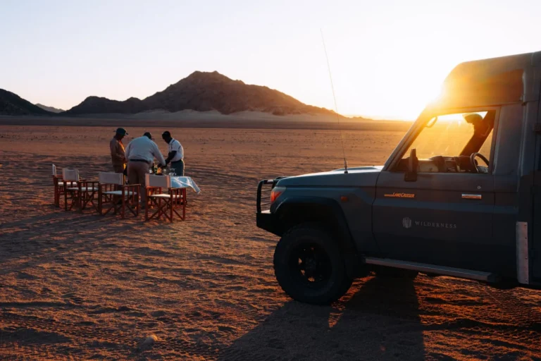 Sunset drinks beside a safari vehicle in the Kulala reserve