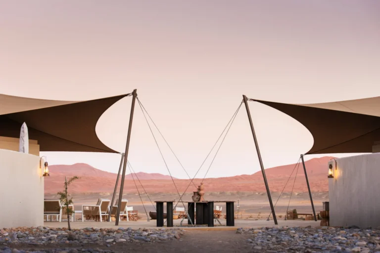 Outdoor dining beneath shade sails at Kulala Desert Lodge