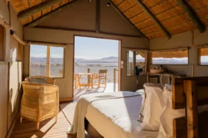 Thatched guest room and sitting area at Kulala Desert Lodge