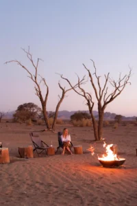 Guests beside the Little Kulala fire pit at dusk