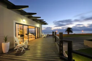 Illuminated lounge and lagoon-facing deck at sunset