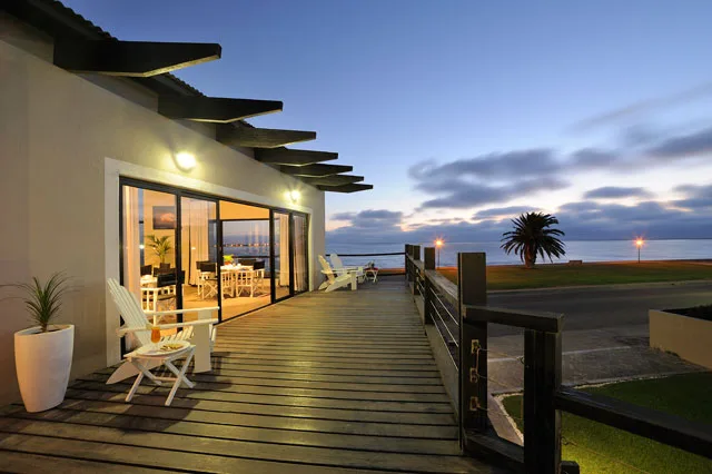 Illuminated lounge and lagoon-facing deck at sunset