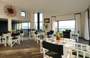 Breakfast tables beside large windows at Oyster Box Guesthouse