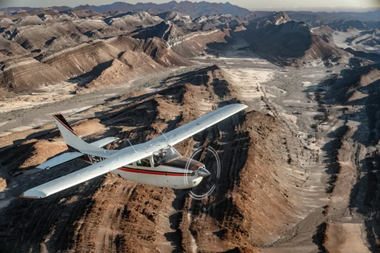 Light aircraft flying above rugged desert ridges on a Skeleton Coast fly-in safari